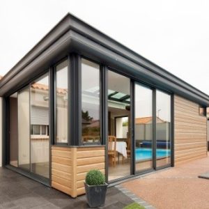 Véranda aluminium et bois devant une piscine